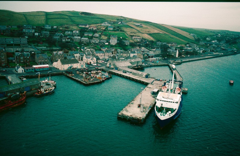 The North Pier, where the P & O Ferries used to dock. It was built in the 1920s for The Thornly Binders seaweed processing factory, which was the larger of the two buildings on the pier. This building was later occupied by James Wilson Wholesale Merchant. © Estate of Keith Allardyce