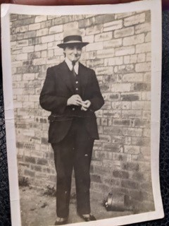 Martha - Susan Boyd’s Great, Great Aunt circa 1940 Image of a black and white photograph depicting Martha stood in front of a brick wall. The photograph is dated to circa 1940. Martha is wearing a three-piece suit, tie and hat.