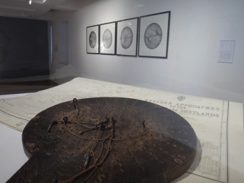 A traverse board in an art gallery, with the artwork inspired by it on the wall.