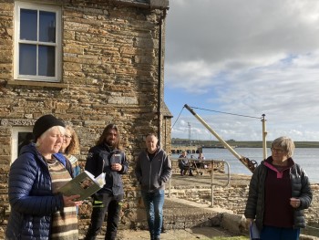 Artist Jenny Pope (far right) and Alison Skene reading a Robert Rendall poem